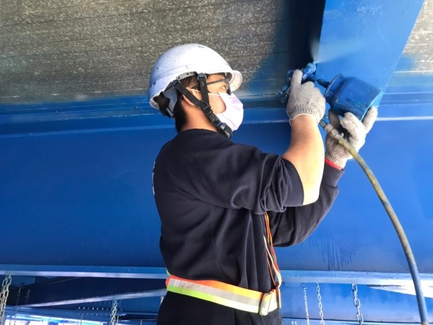 工程人員專注的進行八安大橋防鏽塗漆，再噴上深藍色的漆，保護橋梁壽命。